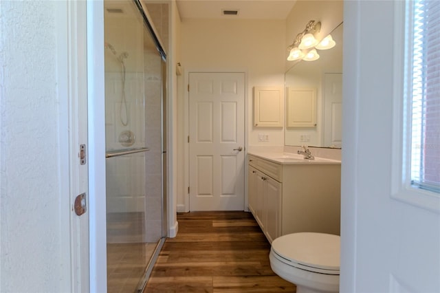 bathroom with vanity, walk in shower, hardwood / wood-style floors, and toilet