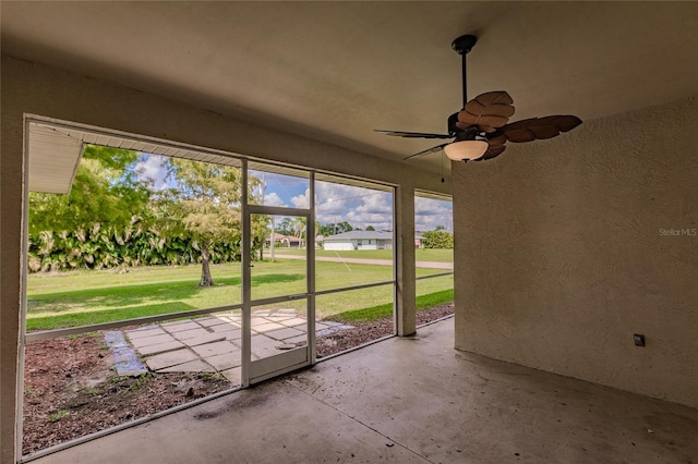 unfurnished sunroom featuring ceiling fan