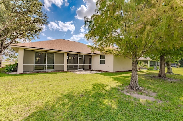 rear view of property with a sunroom and a lawn