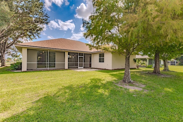 rear view of house with a sunroom and a lawn