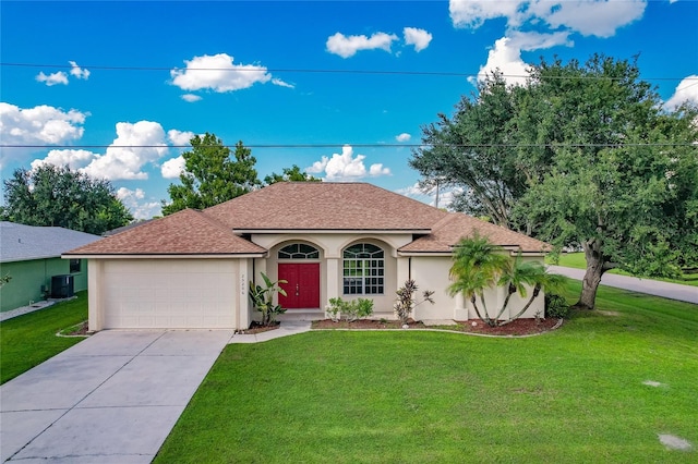 view of front of house featuring a front yard, a garage, and central AC