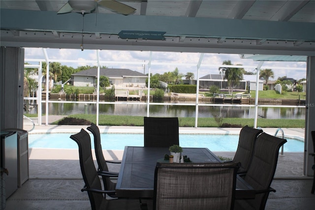 view of swimming pool featuring a lanai, a water view, ceiling fan, and a patio area