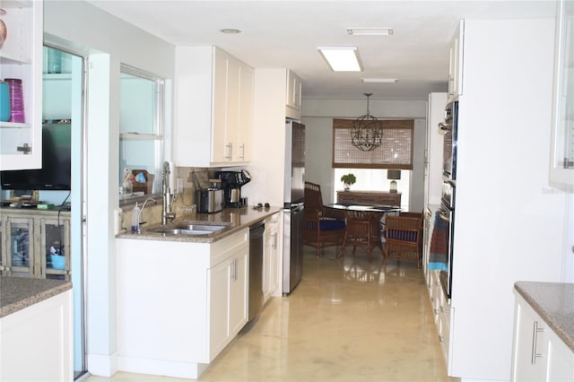 kitchen with stainless steel appliances, white cabinetry, sink, a chandelier, and pendant lighting