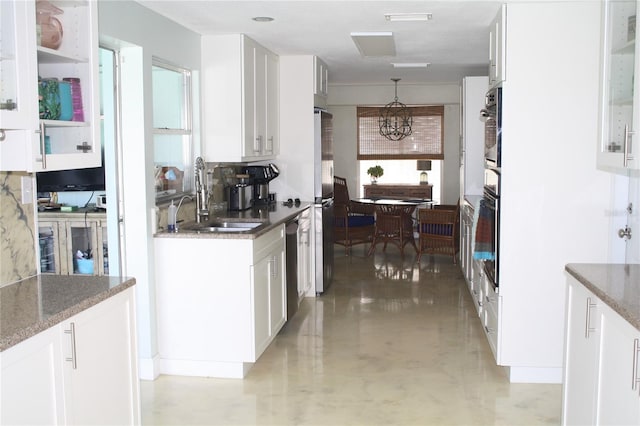 kitchen with white cabinets, dark stone countertops, sink, and stainless steel appliances