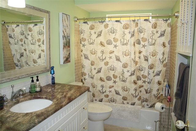 bathroom with vanity, toilet, and backsplash