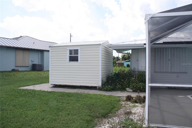 view of property exterior featuring central AC unit, a lawn, and a storage shed