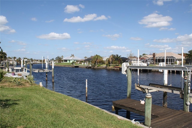 view of dock featuring a lawn and a water view