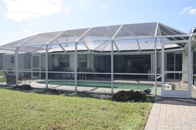 back of property with a lanai, a yard, and a patio area