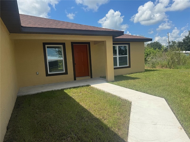 doorway to property with a lawn