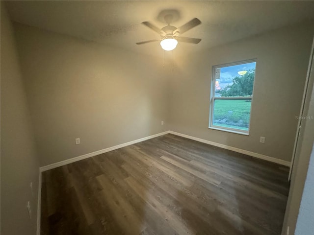 empty room with ceiling fan and dark wood-type flooring