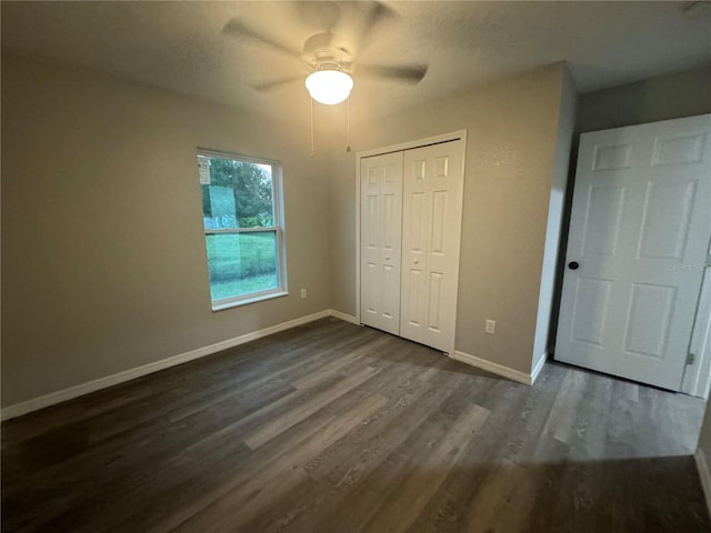 unfurnished bedroom featuring a closet, ceiling fan, and dark wood-type flooring