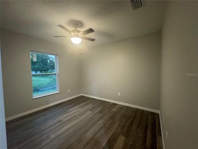 spare room featuring ceiling fan and dark hardwood / wood-style flooring