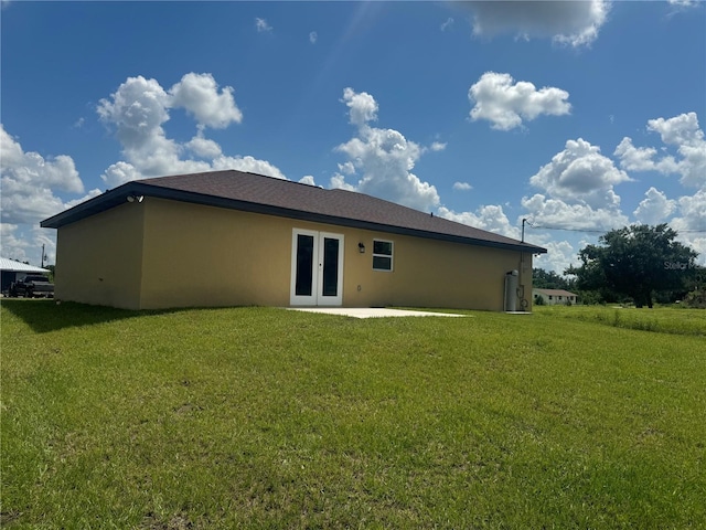 back of property with french doors, a yard, and a patio area