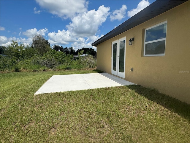 view of yard with french doors and a patio