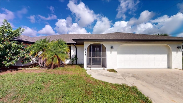 ranch-style house featuring a garage and a front lawn