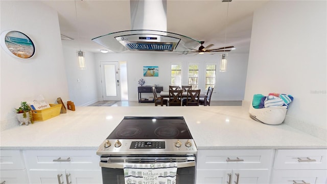 kitchen with light stone counters, pendant lighting, ceiling fan, white cabinetry, and stainless steel range with electric cooktop