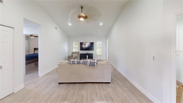 living room with lofted ceiling, ceiling fan, light hardwood / wood-style floors, and a fireplace