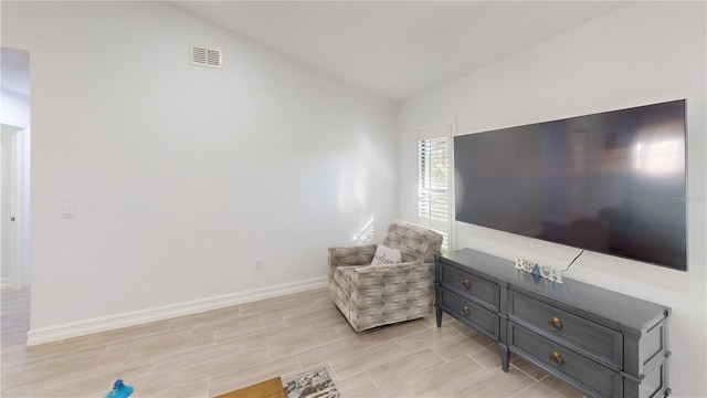 sitting room with lofted ceiling and light wood-type flooring