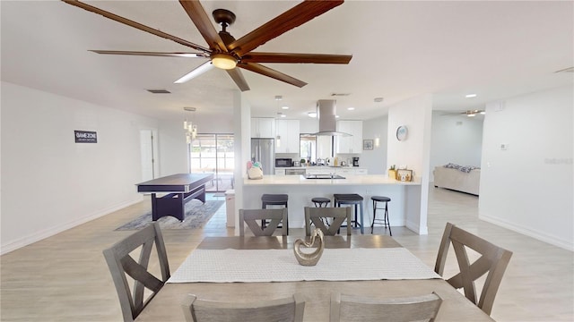 dining area with ceiling fan and light hardwood / wood-style flooring