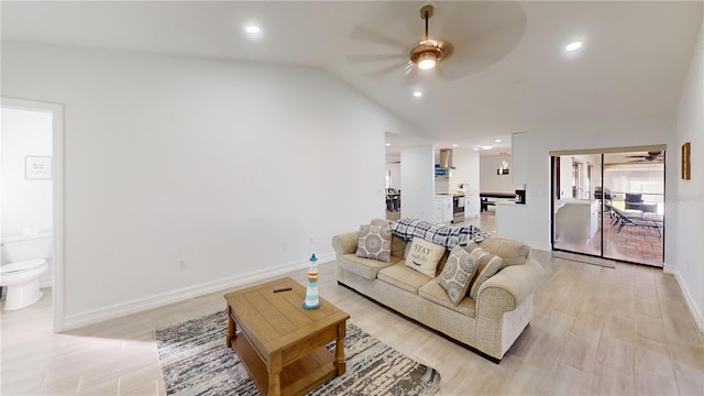 living room featuring ceiling fan, lofted ceiling, and light wood-type flooring