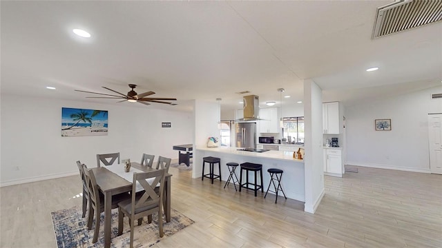 dining space with ceiling fan, light hardwood / wood-style flooring, and lofted ceiling