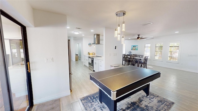 recreation room featuring ceiling fan and light hardwood / wood-style flooring