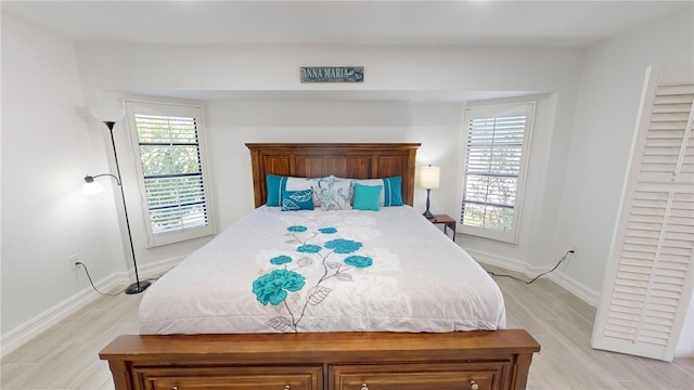 bedroom with light hardwood / wood-style flooring and multiple windows