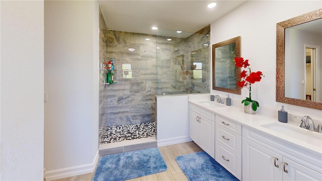 bathroom with wood-type flooring, vanity, and tiled shower