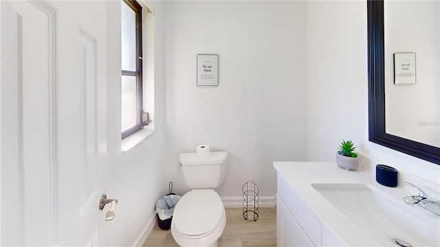 bathroom featuring vanity, toilet, and a wealth of natural light