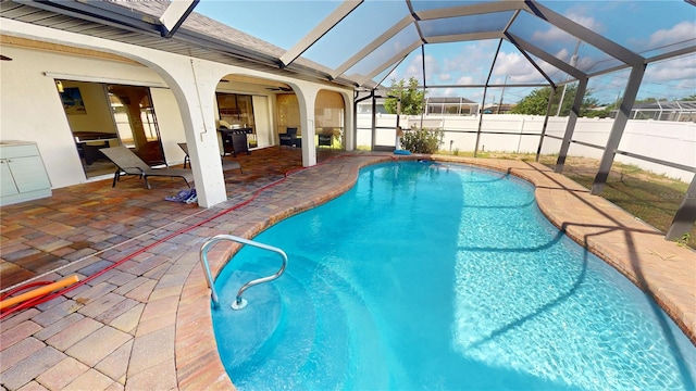 view of pool featuring glass enclosure, a grill, and a patio area