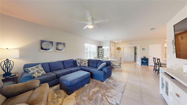 living area featuring a ceiling fan, visible vents, and light tile patterned floors