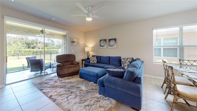 living room with light tile patterned flooring, a ceiling fan, and baseboards