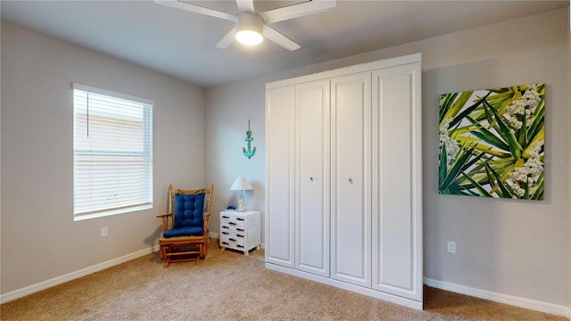 sitting room featuring light carpet and ceiling fan