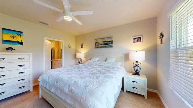 bedroom with ensuite bath, ceiling fan, and light colored carpet