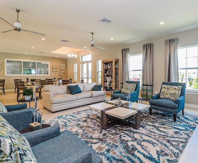 living room featuring light tile patterned floors and ceiling fan with notable chandelier