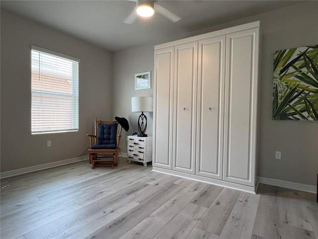 bedroom featuring light wood-style floors, baseboards, and a ceiling fan