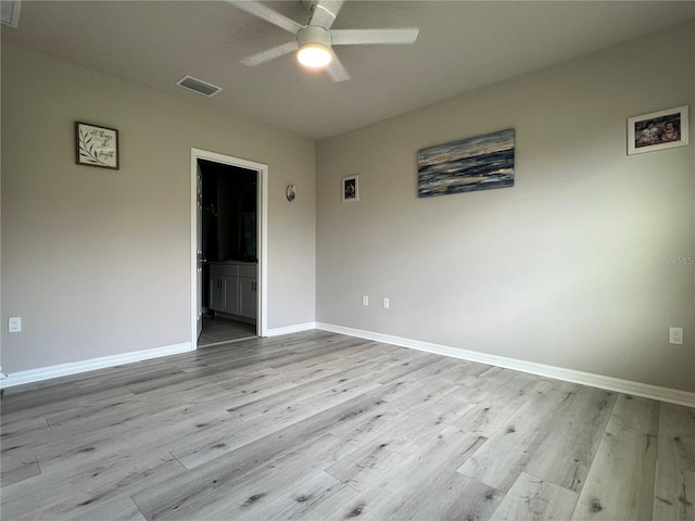 spare room with baseboards, ceiling fan, visible vents, and wood finished floors