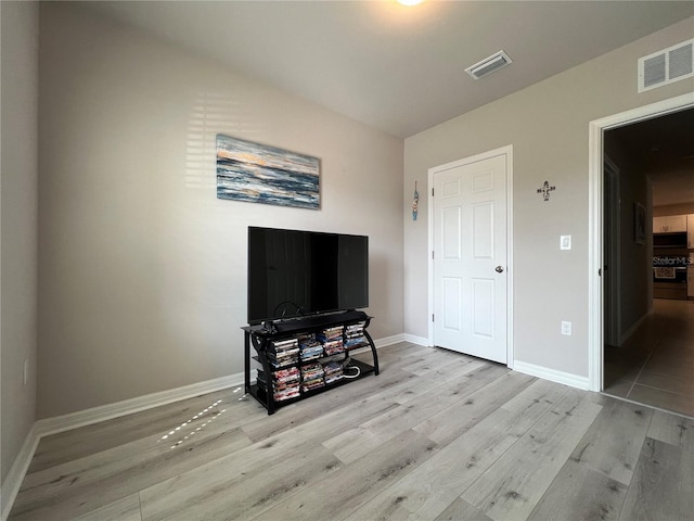 bedroom featuring baseboards, visible vents, and wood finished floors