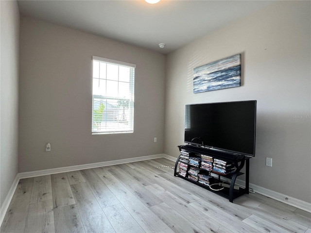 living area with baseboards and wood finished floors