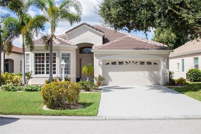 mediterranean / spanish-style house with a garage and a front lawn