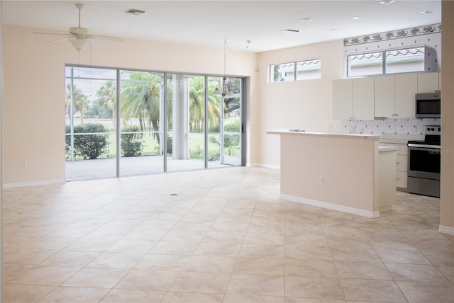 kitchen featuring light tile patterned floors, stainless steel appliances, a wealth of natural light, and ceiling fan