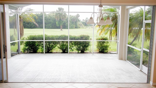 unfurnished sunroom featuring a notable chandelier and plenty of natural light