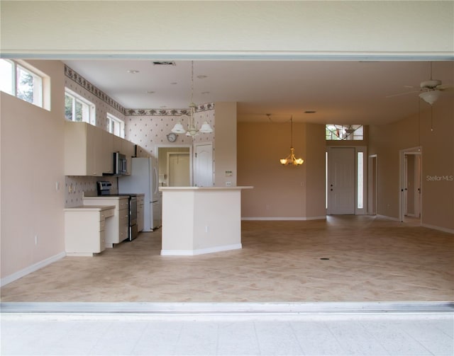 kitchen featuring ceiling fan with notable chandelier, white cabinetry, appliances with stainless steel finishes, and hanging light fixtures