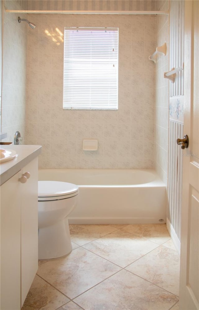 full bathroom with tiled shower / bath, vanity, tile patterned flooring, and toilet