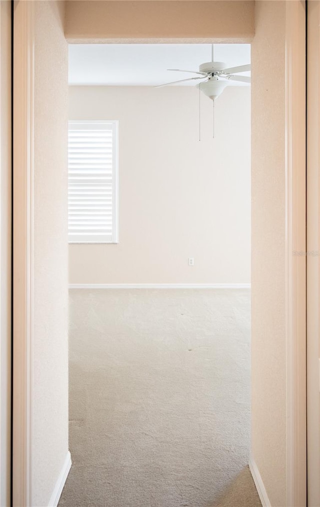 carpeted spare room with ceiling fan