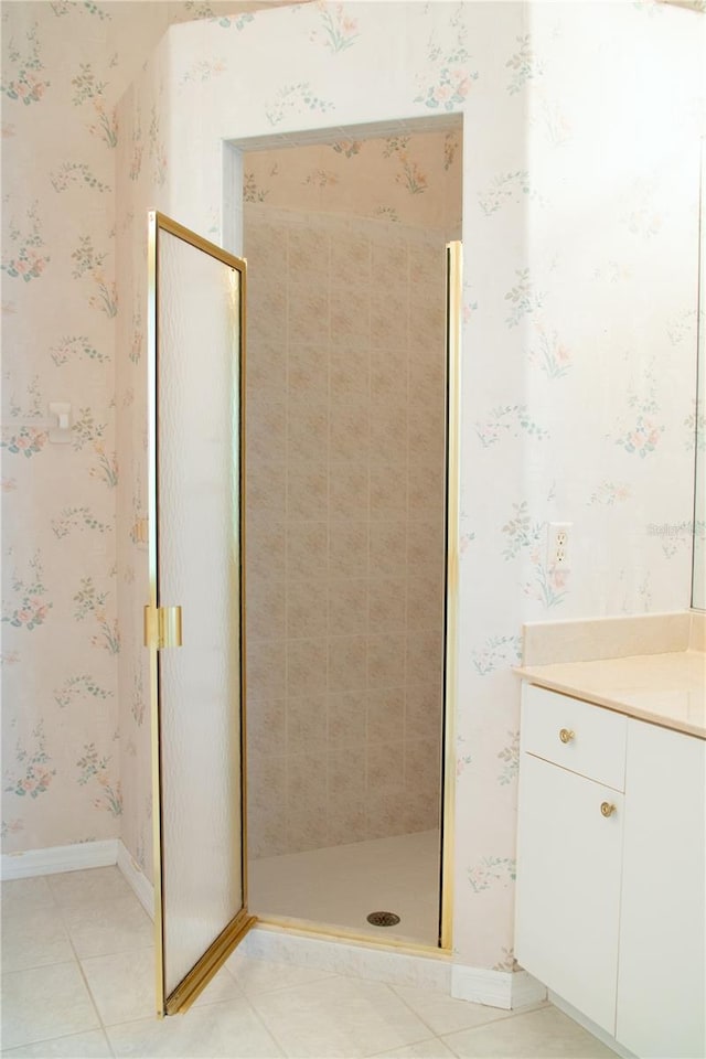 bathroom featuring a tile shower, tile patterned floors, and vanity