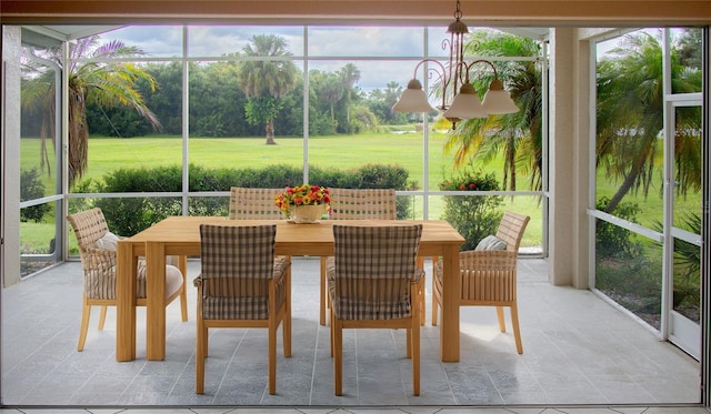 sunroom / solarium with a notable chandelier