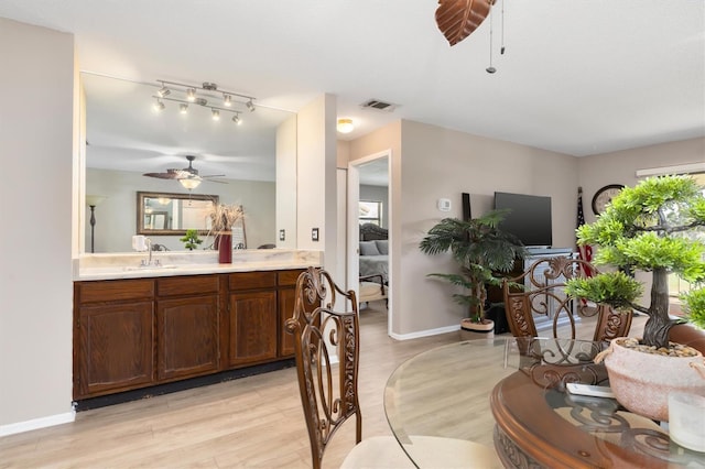 dining space with ceiling fan, sink, and light hardwood / wood-style flooring