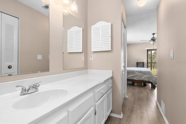 bathroom with hardwood / wood-style floors, vanity, and ceiling fan