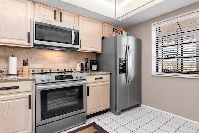 kitchen featuring light brown cabinetry, appliances with stainless steel finishes, and decorative backsplash